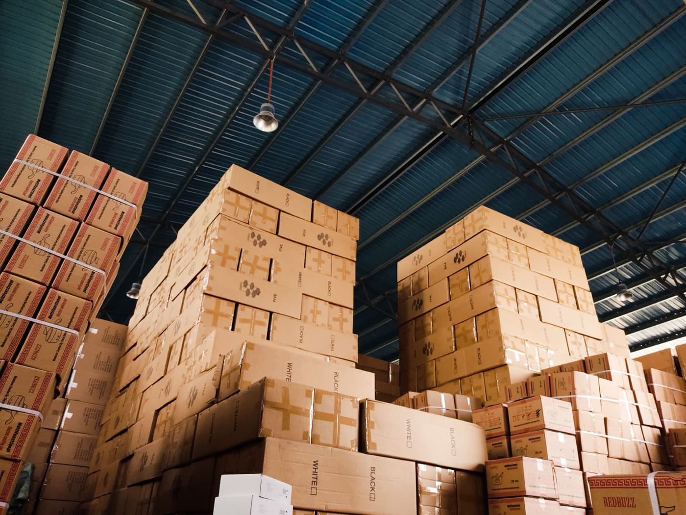 Cartons empilés dans un entrepôt en période de forte activité